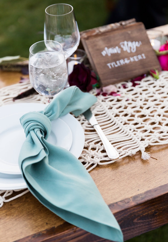 deco champetre bord de mer avec serviette bleue nouée en noeud, centre de table en mailles, centre de table floral