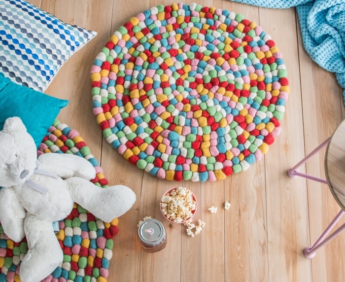 faire un tapis de jeu enfant multicolore, modèle de tapis en pompon mini, idée déco chambre d'enfant avec objets personnalisés