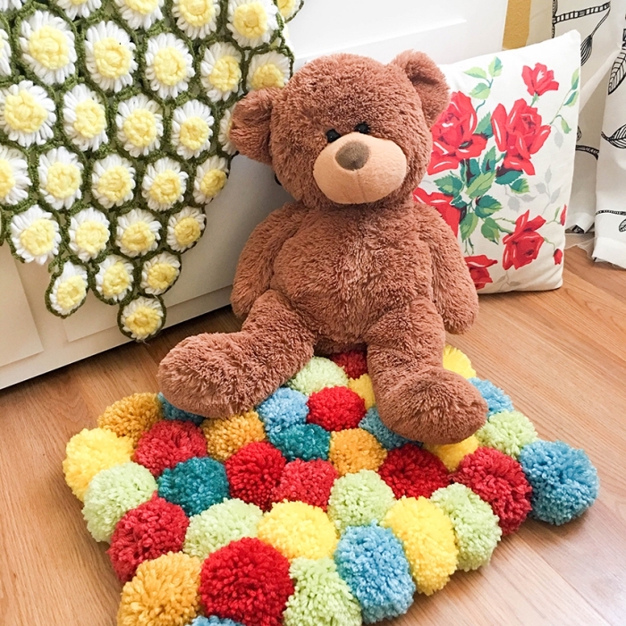 idée pour réaliser un tapis de jeu enfant multicolore, modèle de tapis en pompon diy pour la chambre d'enfant