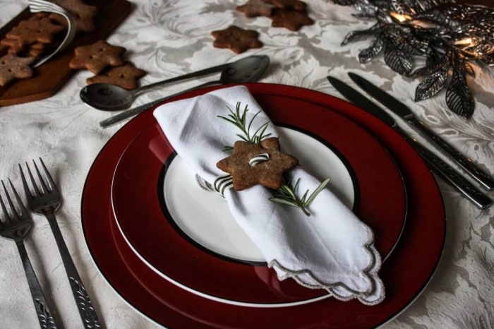 modèle de pliage de serviette facile pour fête, idée déco table fête avec assiettes rouges et serviettes blanches