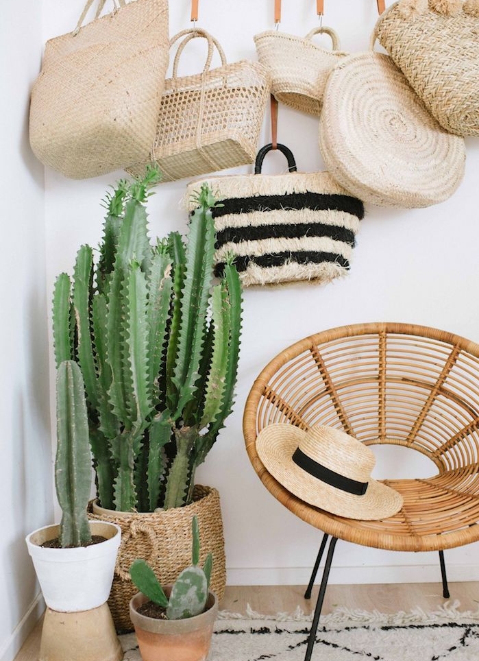 chaise en rotin exotique sur pieds metallique, deco mural sac cabas et cactus plantés en pot et dans un panier rotin, deco cactus tropicale