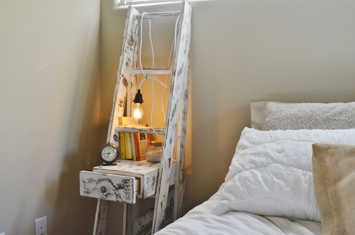 echelle decorative recyclée en bois patiné blanchi avec tiroir, ranger livres, réveil, lampe ampoule, linge de lit blanc