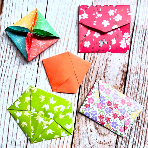 enveloppes en origami avec motifs colores sur une surface en bois
