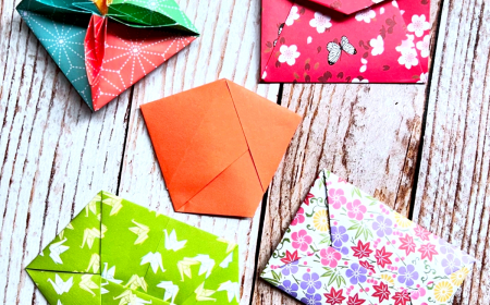enveloppes en origami avec motifs colores sur une surface en bois