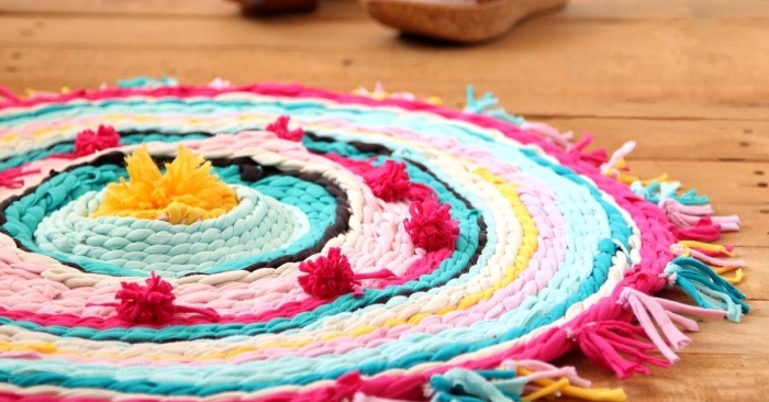 modèle de tapis rond tressé en bandes de tissu coloré avec décoration en tassels et pompons, activité manuelle ado facile