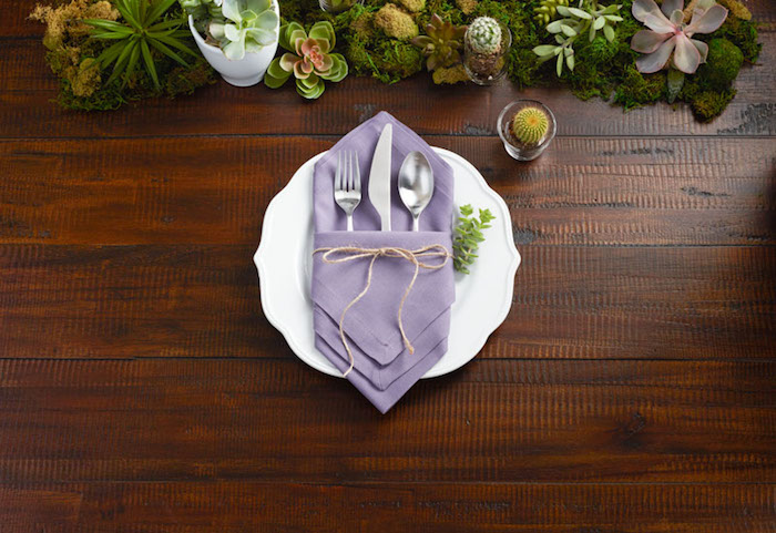 comment decorer la table de mariage, pliage serviette tissu couleur violette en forme de diamant, table bois et centre de table de plantes
