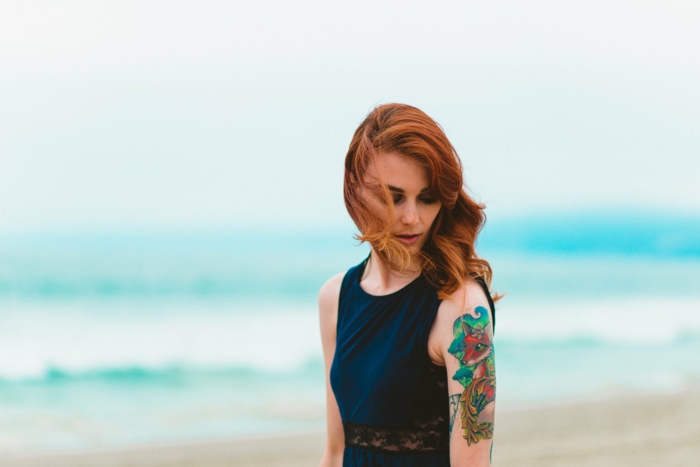 Original tatouage plume qui peut etre combine avec tatouage renard coloré sur le bras, magnifique idée tatouage art pour femme, photo au bord de la mer