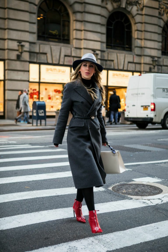 jeune femme se promène dans la cité, manteau veste gris, chapeau feutre, bottes rouges