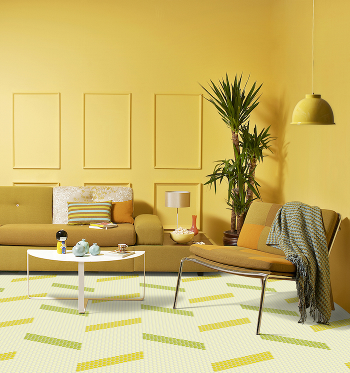 deco salon jaune avec un canapé jaune moutarde et chaise jaune, table minimaliste blanche, palmier interieur en pot