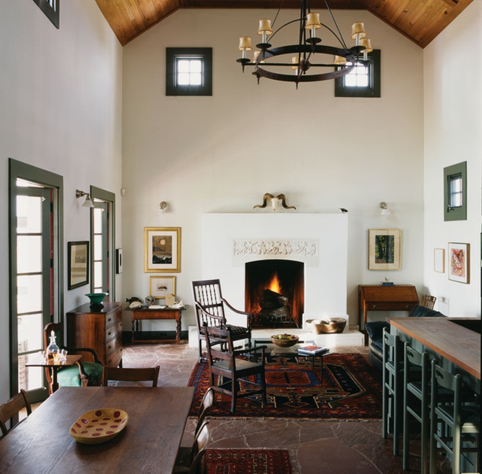 deco maison de campagne cosy, table en bois foncé, sol en pierre rouge, chandelier noir, rénovation d'ancienne grange, grande cheminée blanche