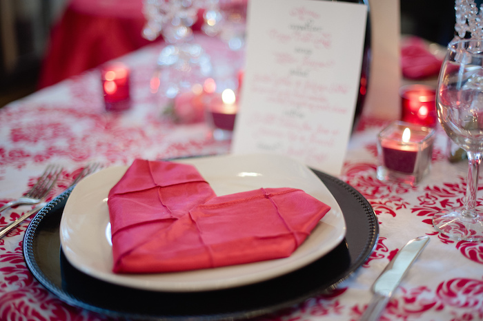 décoration romantique de table avec nappe blanche à motifs fleuris rouges, serviette en forme de coeur rouge, deco bougies miniatures