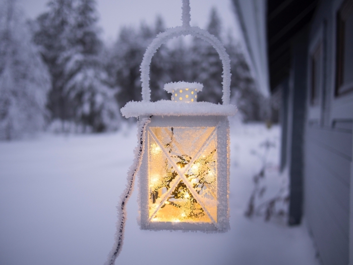 joli fond d écran noel, image lanterne allumée devant une maison de forêt enneigée, idée photo gratuite sur thème hiver