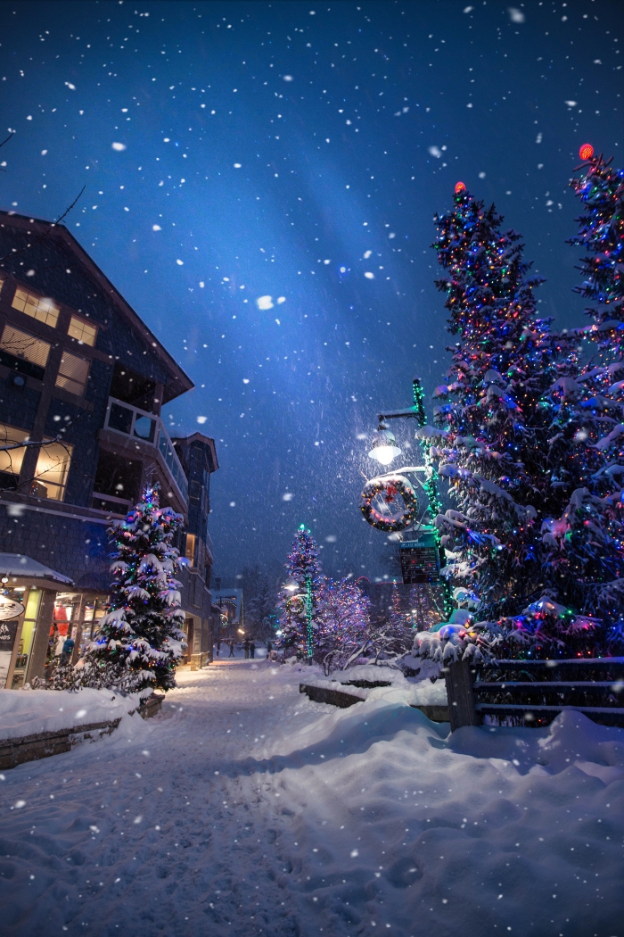 image de noel gratuite a telecharger, photo chute de neige dans un village décoré pour la fête de noel avec guirlandes et lumières