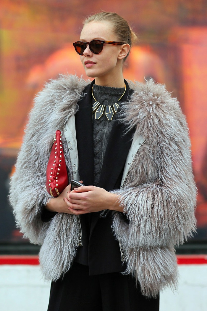 femme d'affaires, collier statement aux pendentifs géométriques, sac rouge, manteau gris poilu