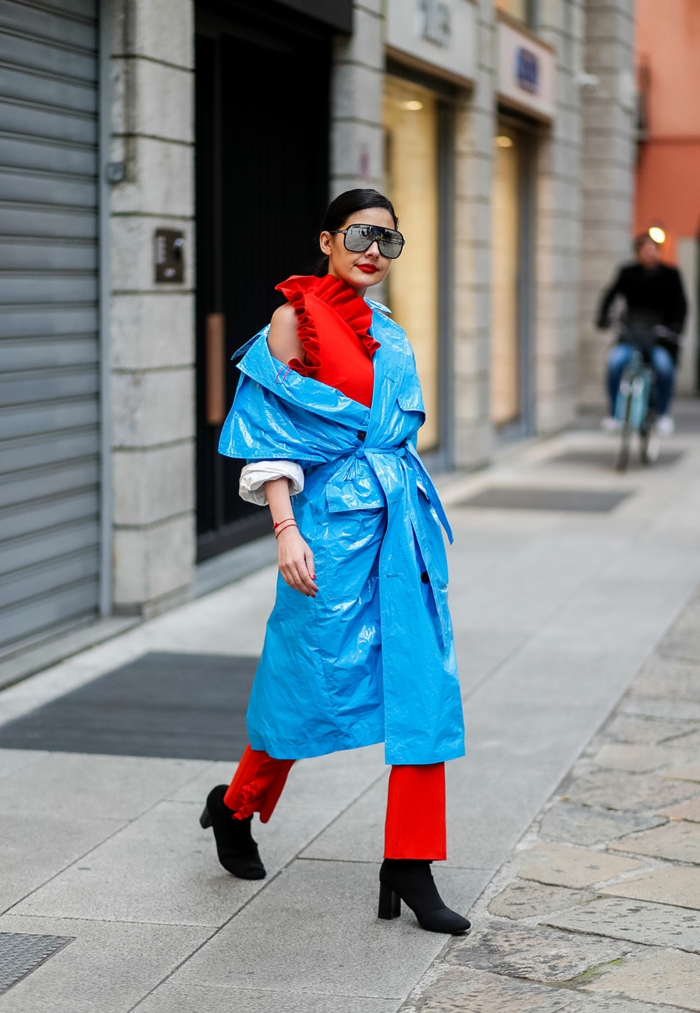 manteau imperméable bleu, pantalon rouge, blouse rouge, lunettes surdimensionnées, femme moderne 