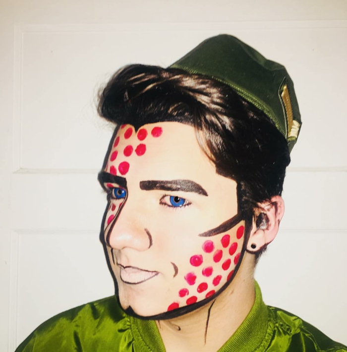 homme au maquillage pop art, chemise verte, pois rouges au visage, lentilles de couleur bleues