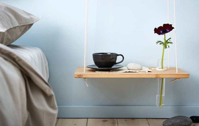 idée simple pour faire une table de chevet suspendue en planche de bois à découper, tasse de café et soliflore sur fond mur bleu ciel
