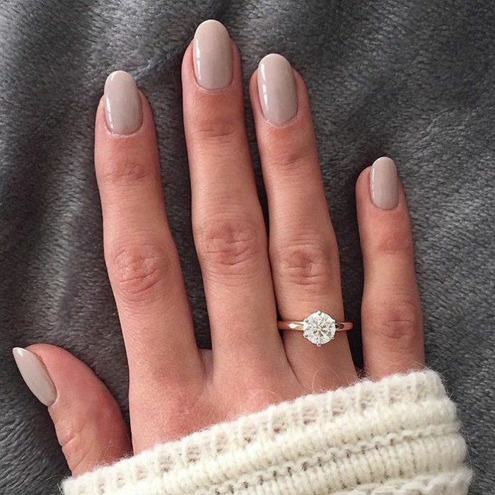 ongles gris clair, bague et pull d'hiver blanc, forme d'ongle ovale, ongles mi-longs