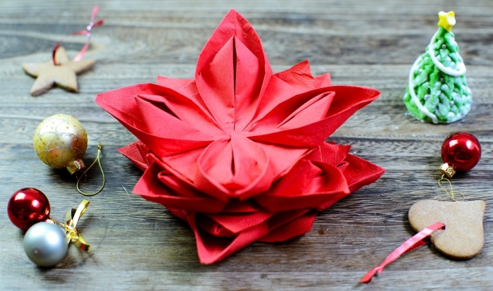 technique de pliage serviette pour noel, idée comment plier une serviette en forme florale, art origami avec serviette rouge