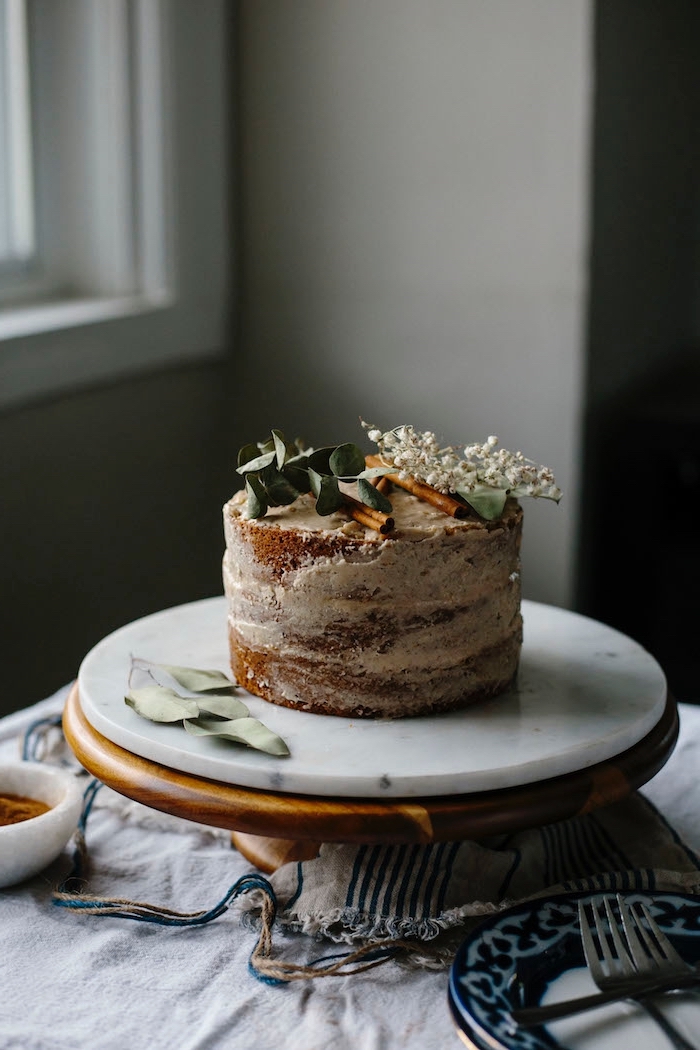 layer cake sans glaçage à la vanille à la garniture de crème aux épices chai, recette de gateau a la vanille vegan décoré de bâtons de cannelle et de fleurs