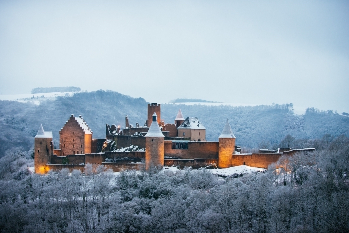 joli paysage d'hiver dans les montagnes avec une forteresse aux lumières allumées, idée fond d'écran noel ou hiver