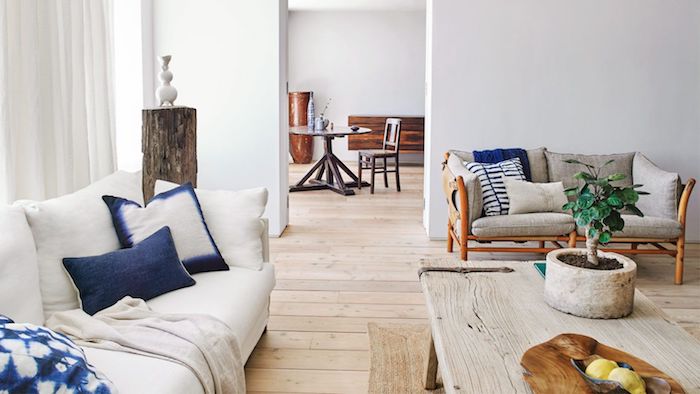deco salon rustique moderne avec un bonsai sur une table basse bois brut, canapé blanc cassé, coussins blanc et bleu marine, parquet bois brut