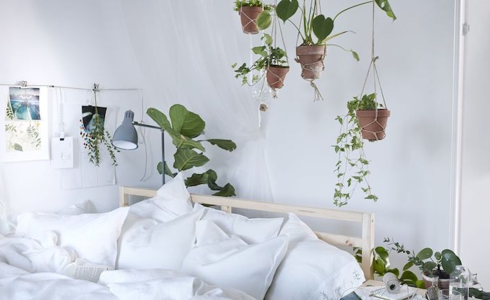 idee deco chambre blanche avec des pots de fleurs suspendus au dessus d un lit bois avec linge de lit blanc, plante d appartement