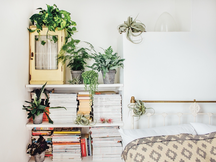 idee de lit metallique avec linge de lit blanc, gris et beige, étagères blanches avec livres et plantes vertes en pot, deco chambre nature