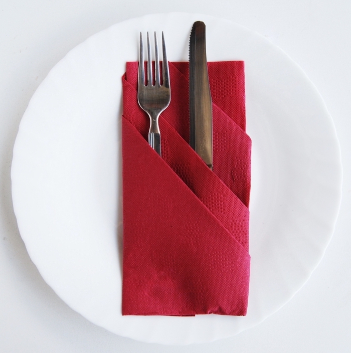 quelles couleurs associer pour la décoration d'une table de Noel, exemple de pliage serviette papier rouge facile