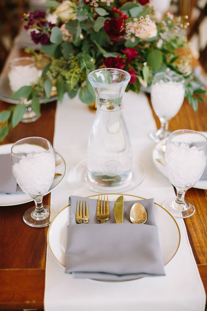 chemin de table blanc avec bouquet de fleurs champetre au centre sur table bois, assiette blanche avec pliage de serviette pour mariage pochette tissu