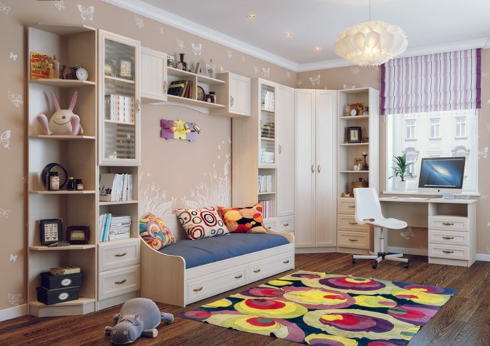 tapis couleurs joyeuses, étagère bibliothèque, sol en bois foncé, plafonnier blanc, armoire dressing d'angle