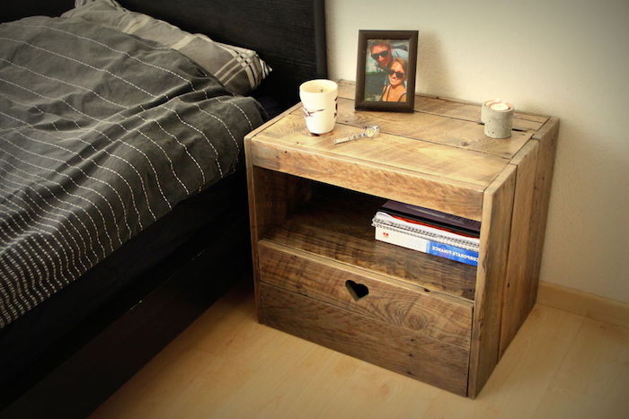 table de chevet en palette, planches de bois décomposées avec rangement pour vos livres de chevet, cadre photo près d un lit décoré de linge de lit gris