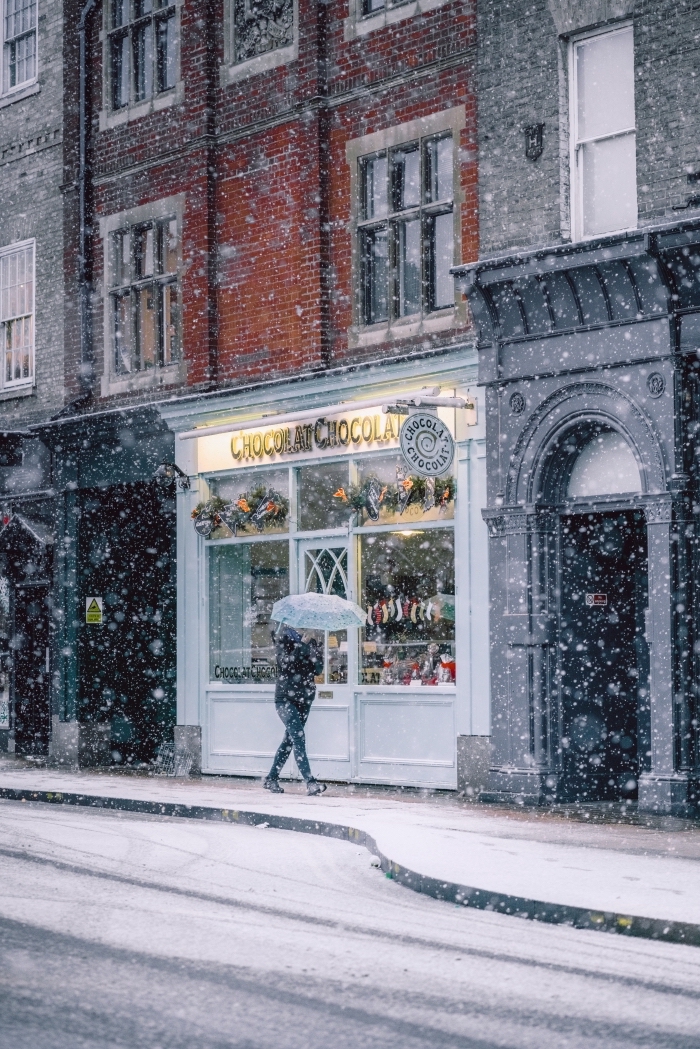 exemple paysage d'hiver pour fond d'écran verrouillage iphone, photo hiver et flocons de neige devant la vitrine d'un magasin décoré pour noel