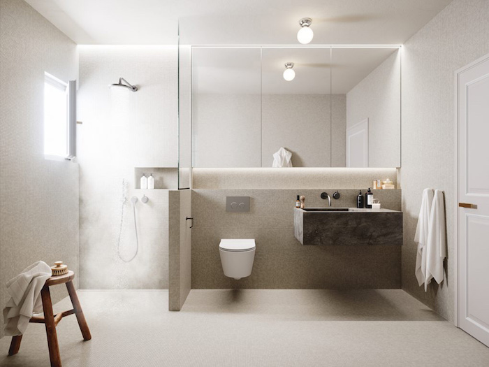 aménagement salle de bain espace ouvert avec douche italienne avec muret et vitre de séparation sur sol en béton ciré