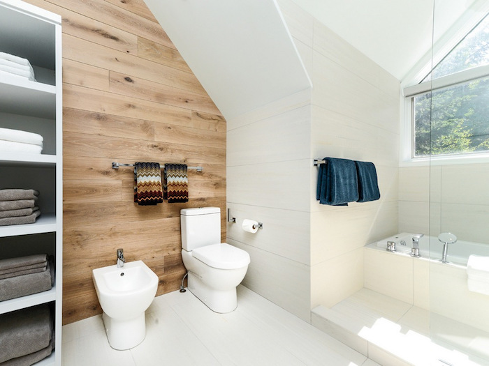 salle de bain scandinave avec mur en bois de parquet et carrelage blanc sur le sol et les murs 