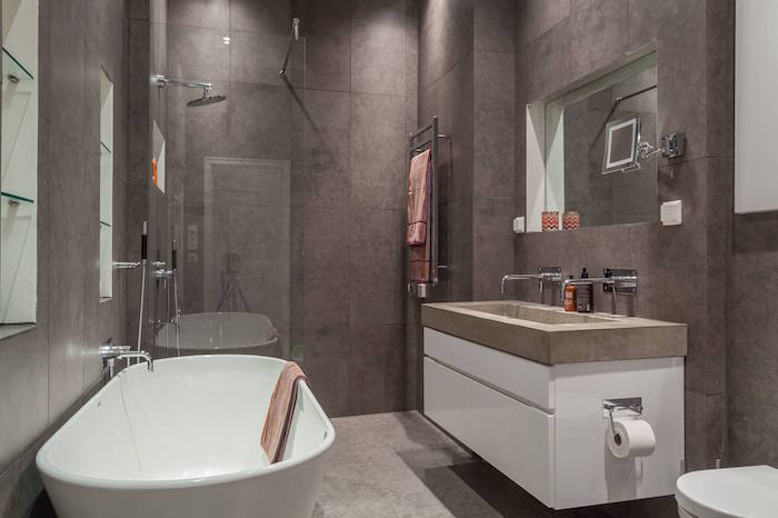 petite sdb gris couverte de carrelage sur les murs et sol en béton ciré avec douche à l italienne et lavabo en ciment type scandinave