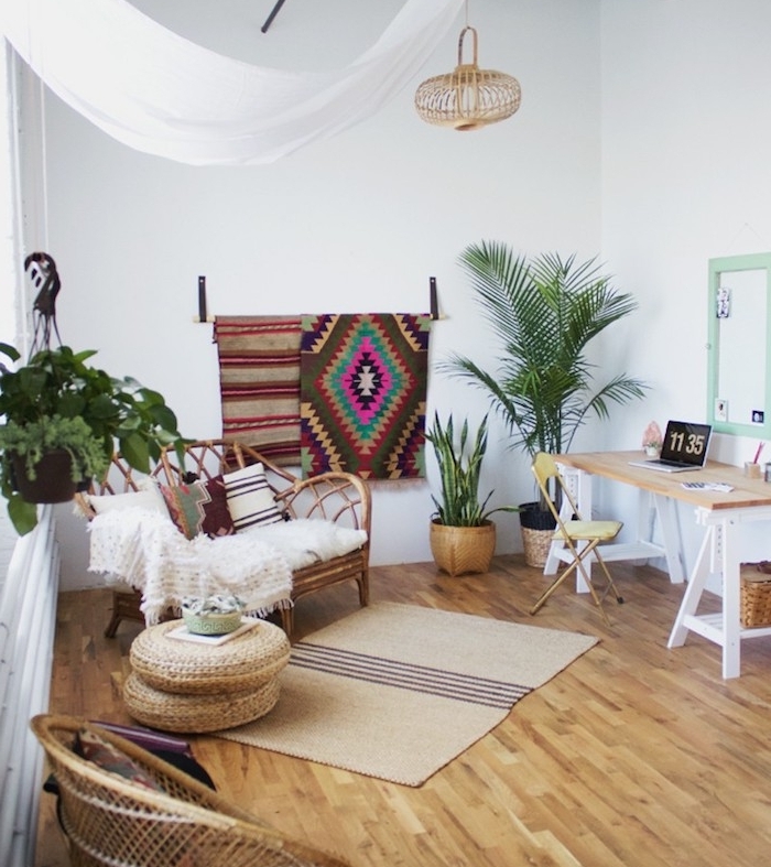 deco boheme chic salon moderne avec coin bureau, fauteuil rotin avec plaid blanc, parquet clair, plantes vertes et tapis deco murale