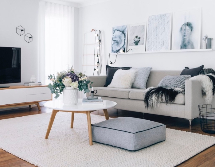 petit salon de style scandinave vintage avec un coin canapé cosy sublimé par une étagère de cadres photos