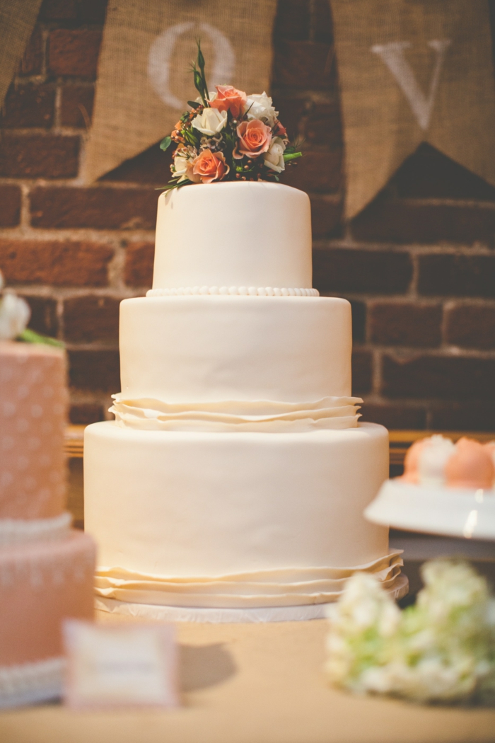 Gâteau de mariage 3 etages, simple gateau blanche couverte de pate a sucre avec perles de creme de beurre et bouquet de fleurs en top