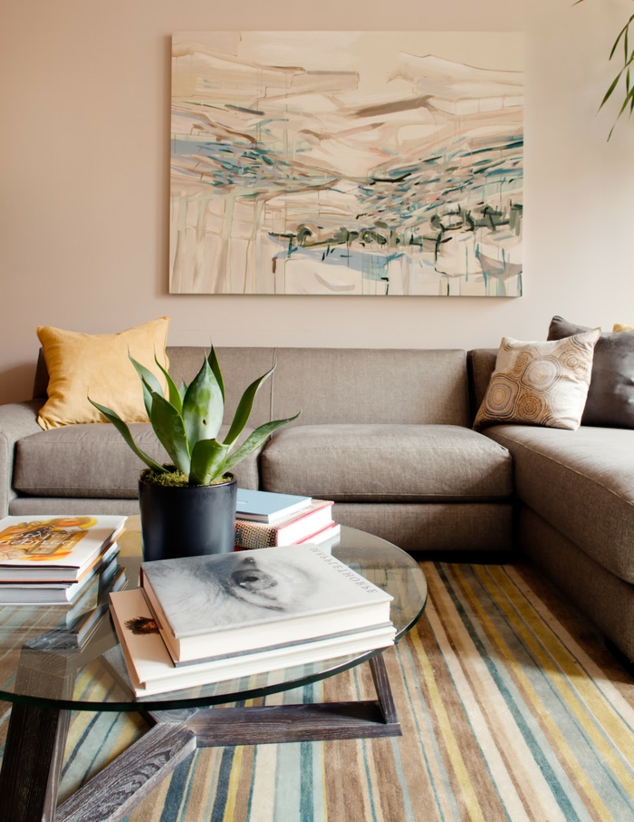 salon gris contemporain, sofa taupe, tableau peinture, pot de fleur avec succulent, livres empilés