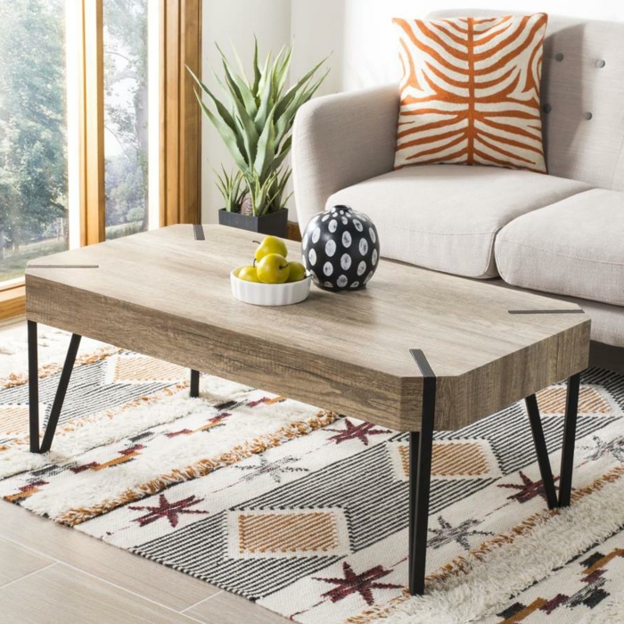 table basse en bois et fer, tapis beige aux motifs graphiques, boule décorative, plante verte, coussin motif animal