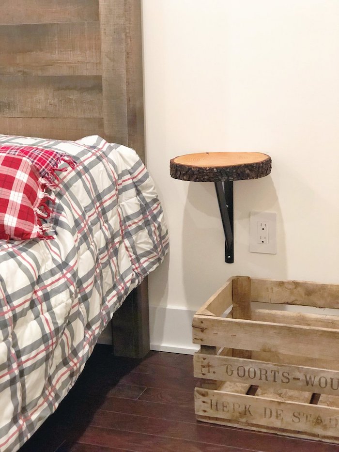 table de nuit miniature en rondin de bois fixé sur un mur avec un support metallique, rangement caisse de bois