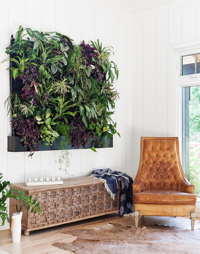 mur végétal intérieur constituée de plantes vertes, chaise en cuir, tapis cuir, murs blancs, parquet clair, deco salon exotique