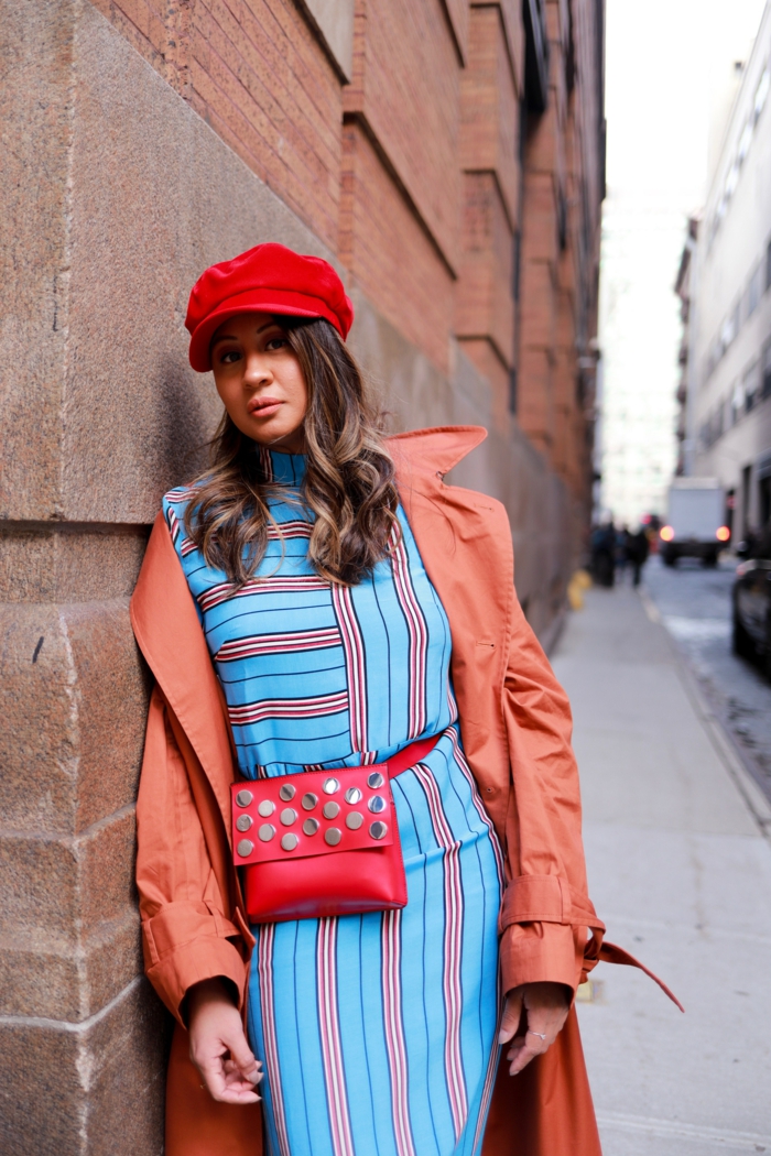 manteau trench, sac rouge, casquette rouge, robe bleue aux rayures verticales et horizontales