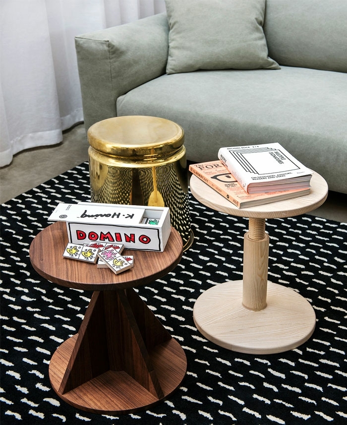 déco originale de salle de séjour, deux petites tables en bois, petite table dorée, tapis noir aux traits blancs, grand sofa