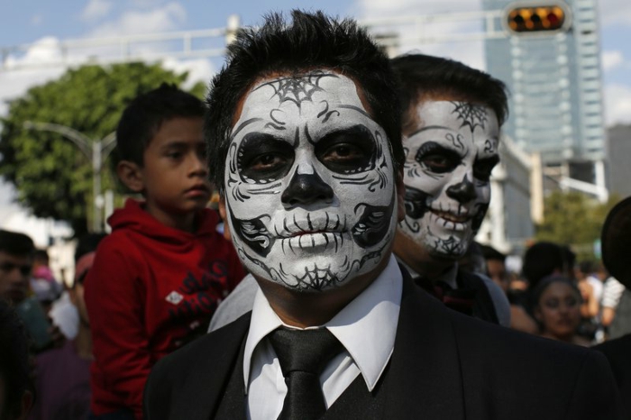 maquillage et déguisement halloween en noir et blanc, crânes apparents dessinés sur les visages