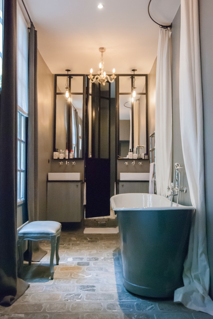 salle de bain en bleu et blanc, tabouret turquoise, miroirs décoratifs, lavabos avec placards compactes, chandelier baroque, grande baignoire turquoise 