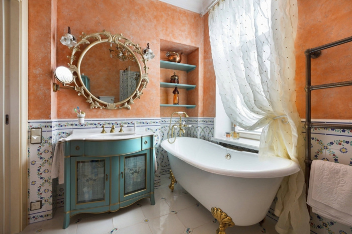 salle de bain aux couleurs contrastantes, grand miroir rond, baignoire asymétrique, miroir au cadre ornementé