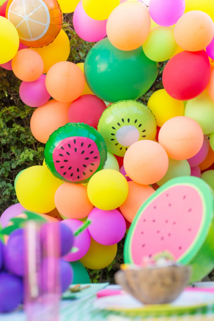 guirlande de ballons fruits tropicaux, ballons pour un party assemblés dans le jardin, ballon kiwi et ballon pastèque