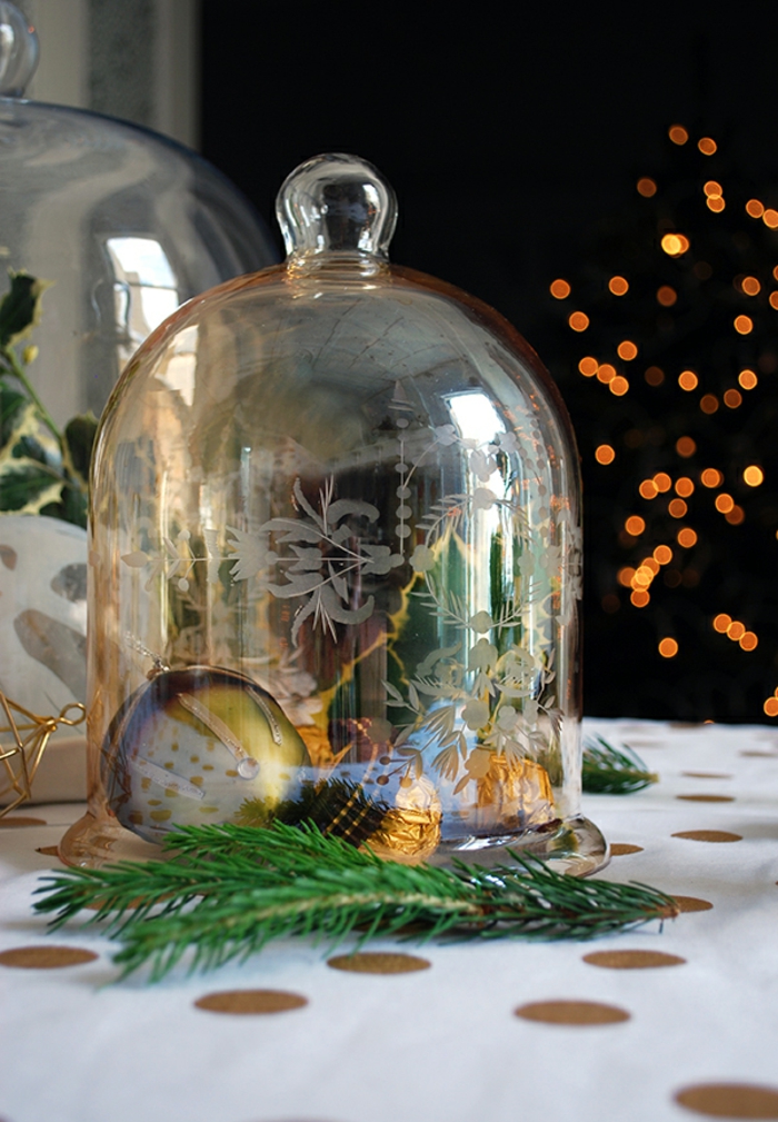 bonbonnière en verre avec boule de noel, bonbons ferrero rocher, nappe blanche à grands points, déco de table pour Noël